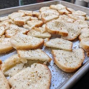 Crostini-bread-slices-laid-out-on-baking-pan-medium-1