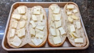 add butter and garlic powder to sub rolls for open steak sandwich recipe