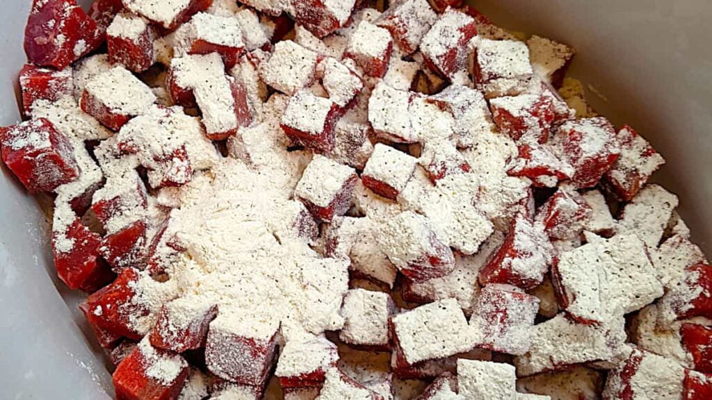 add flour to coat the london broil cubes in the slow cooker