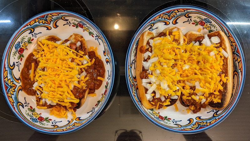 adding final toppings to chili dogs