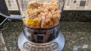 adding hummus main ingredients to hummus blender