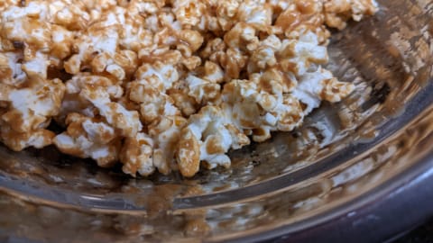adding ingredients to popcorn in mixing bowl