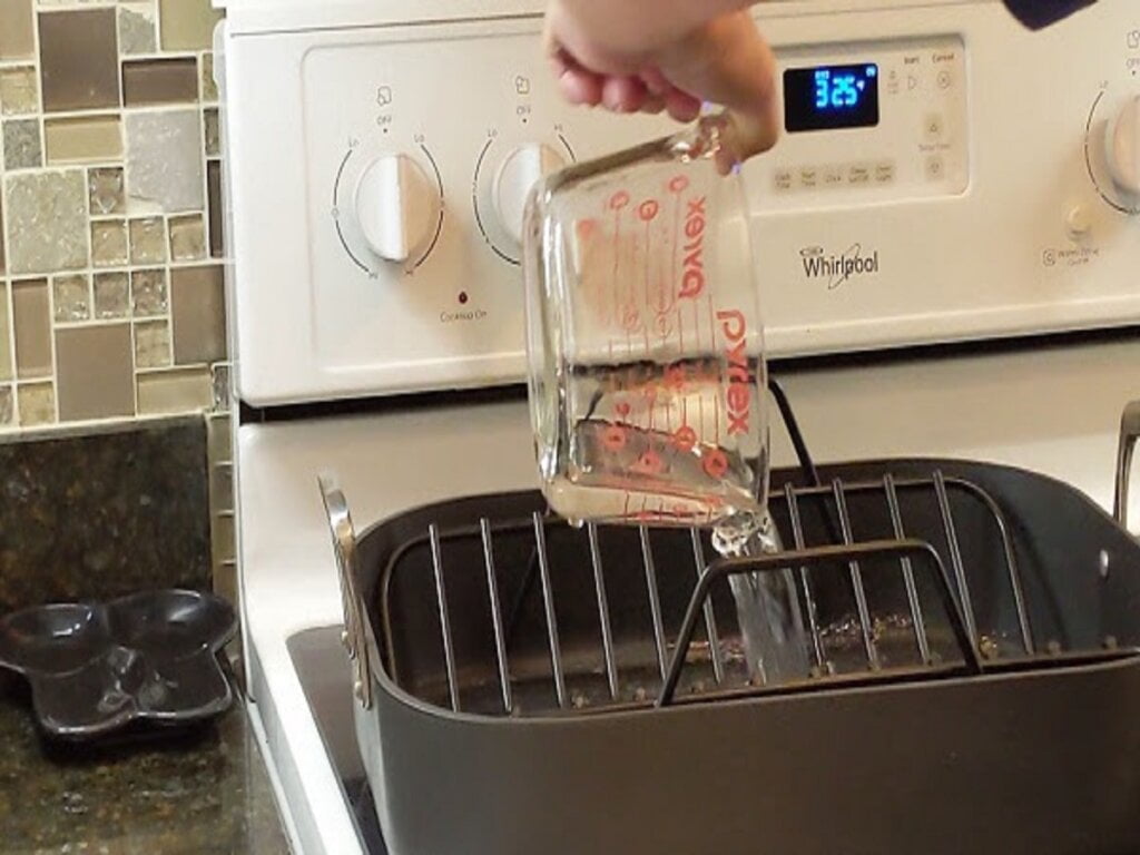 adding initial water to roasting pan for later basting