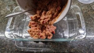 adding layer 1 refried beans mixture to 7 layer dip recipe