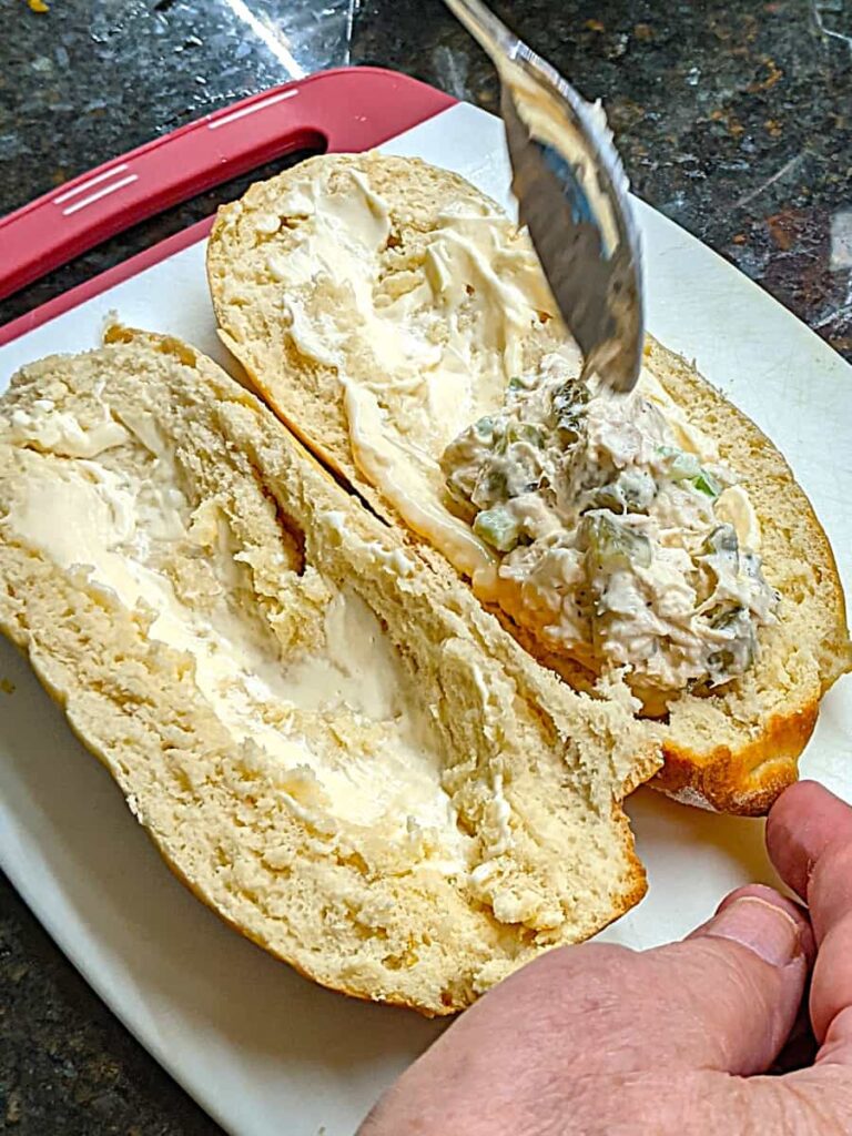 adding meat mixture to recipe for chicken salad submarine sandwich