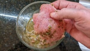 adding meat to marinade for pan fried cuban stuffed pork chops recipe