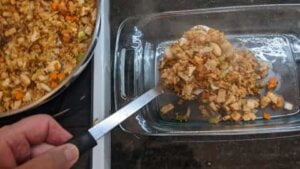 adding mixture to baking dish for asian chicken rice casserole