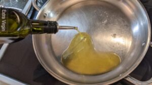 adding oil to preheated pan for sunny side up eggs recipe