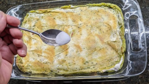 adding salt to enhance seasoning on the sour cream layer of 7 layer bean dip