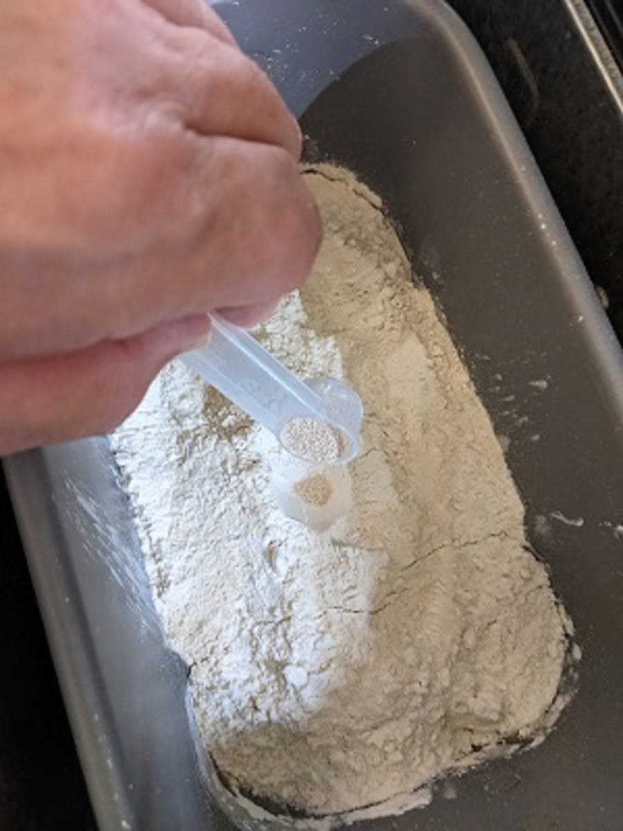 Adding yeast in a crater for pizza dough in bread machine