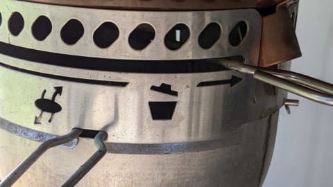 Adjusting kettle bottom vent for indirect heat adjusting kettle bottom vent for indirect heat