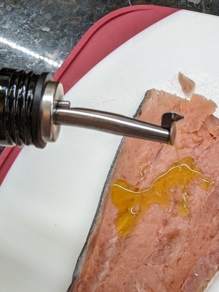 Applying oil to salmon