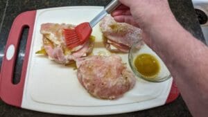 brush coating mixture onto meat for grilled cuban stuffed pork chops recipe