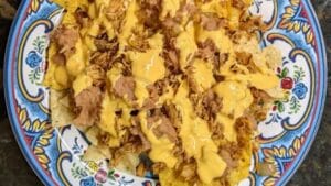 building chicken nachos adding cheese