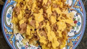 building chicken nachos adding cheese