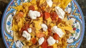 building chicken nachos by adding sour cream