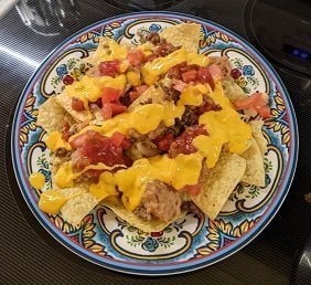 Building ground beef nachos and adding cheese