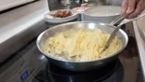 chop up and turn over scrambled eggs in stainless steel pan
