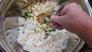 combining rice veggies seasonings to coat well for asian chicken rice casserole