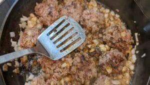 cooking small burgers in onions and smashing after turning for sliders recipe