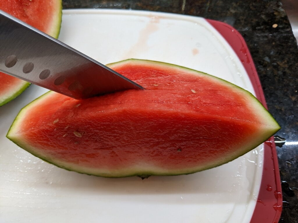 Cut rows of slits in the watermelon wedge cut rows of slits in the watermelon wedge