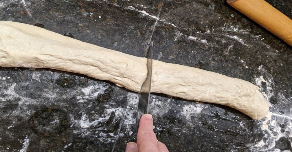 cutting french bread into 2 rolls