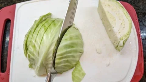 cutting half of cabbage head for a recipe