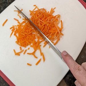 cutting shredded carrots for salad with romaine lettuce