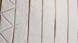 cutting the crescent roll dough for the mini pigs blanket recipe