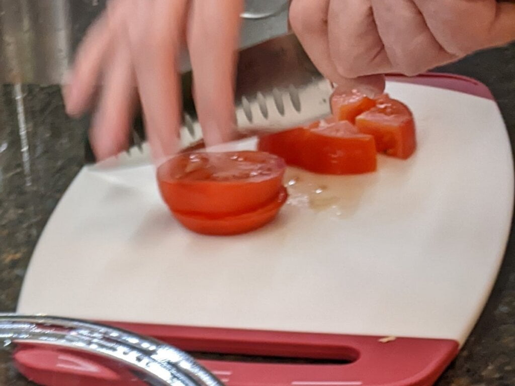 Cutting tomatoes for cucumber tomato salad with ranch dressing