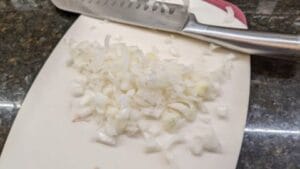 Onions being diced for a baked beans casserole using canned beans