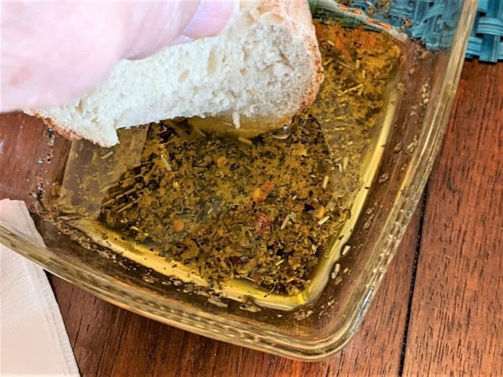 Dipping bread after making olive oil dip recipe for bread