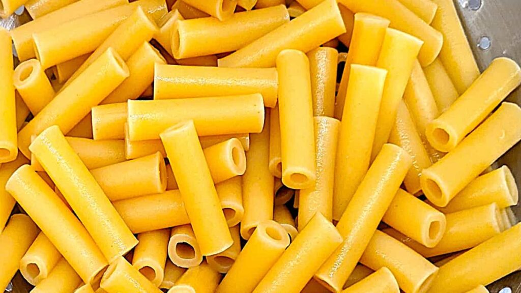 draining penne pasta for pasta in marinara sauce