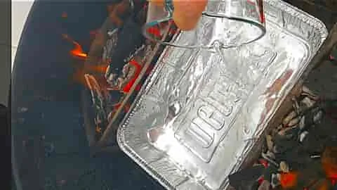 filling drip pan for spiral ham on the grill