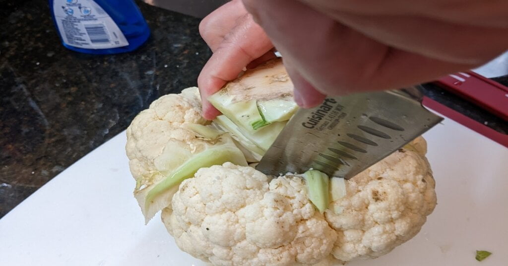 final deep cut into core edges of cauliflower