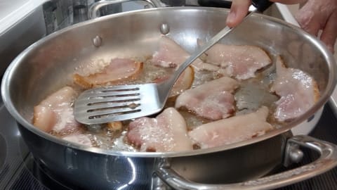fixing curling bacon using spatula to hold down