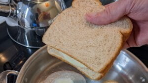 grilled cheese cooking in butter in skillet