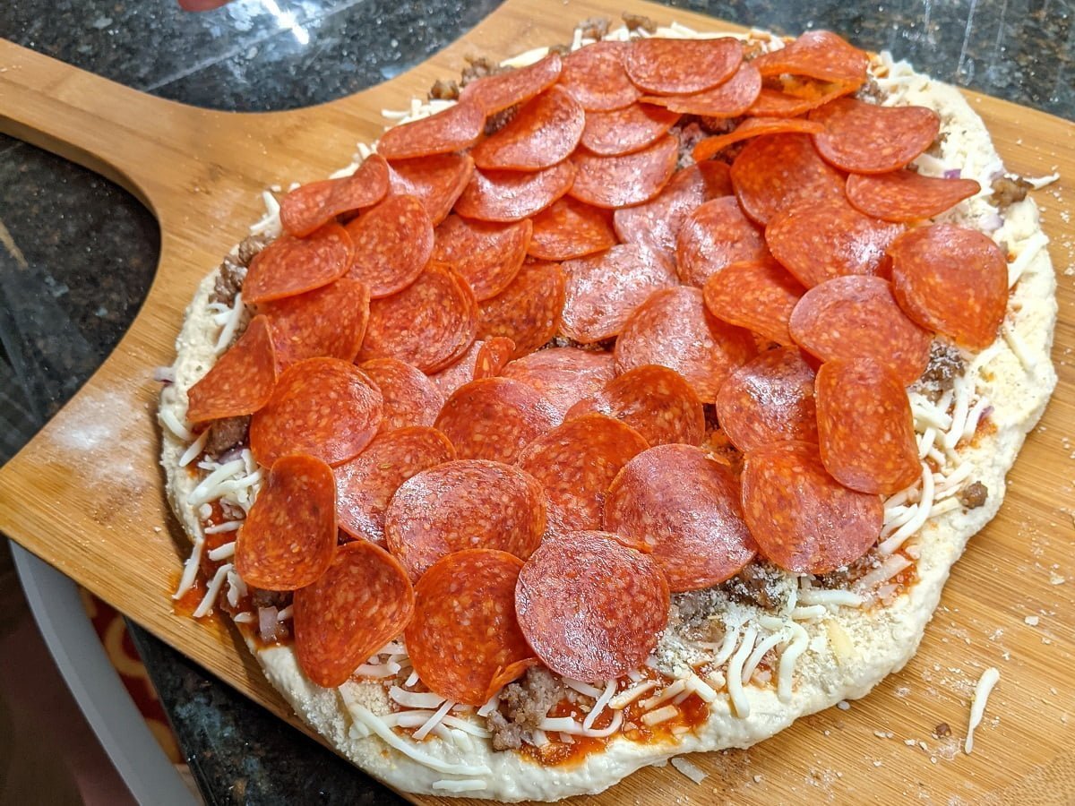 Homemade sausage and pepperoni pizza ready for oven