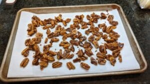 honey roasted pecans with brown sugar ready for baking on parchment papered baking sheet