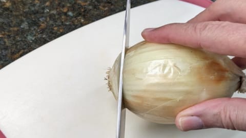 cutting an end of an onion how to peel onions without crying starts by cutting an end off