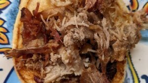 layering pulled pork to sandwich bun