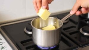 melting butter in saucepan to make mustard and honey glaze for ham recipe