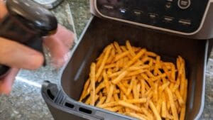 optional spraying peanut oil onto checkers fries for air frying recipe instruction
