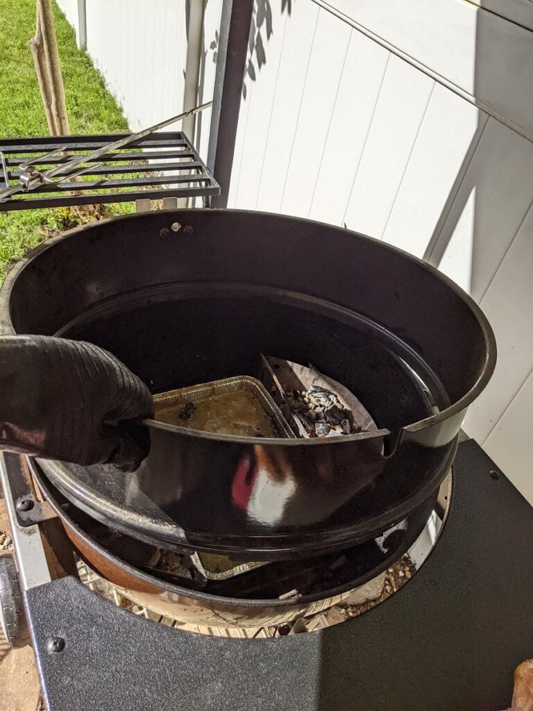 placing weber rotisserie ring onto hot grill