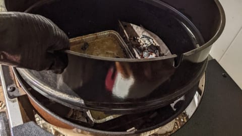 placing weber rotisserie ring onto hot grill