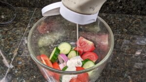 pouring ranch dressing for cucumber tomato salad