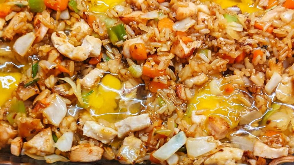 prep step adding eggs to asian chicken and rice casserole