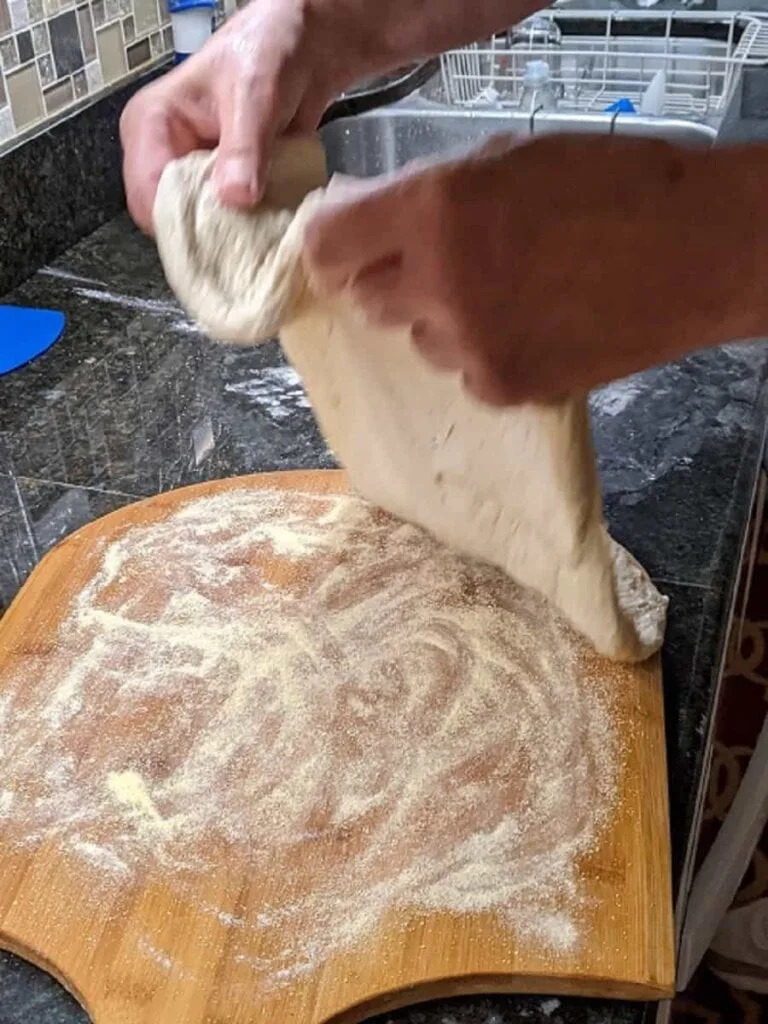 preparing to transfer to oven to par bake pizza dough