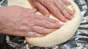 Pressing out pizza dough from bread machine for shaping