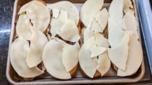 provolone cheese on top of open faced steak sub rolls